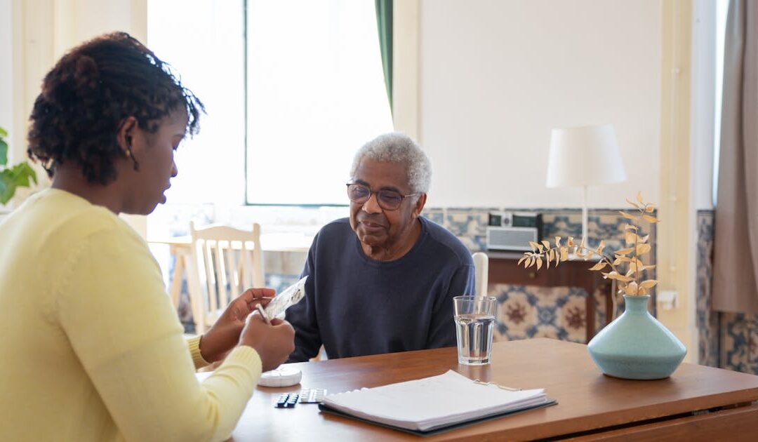 Caregiver discussing medication with senior for home care in Edmonton