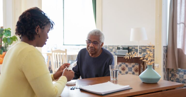 Caregiver discussing medication with senior for home care in Edmonton