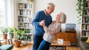 Older couple dancing together in their living room with bookshelves and plants