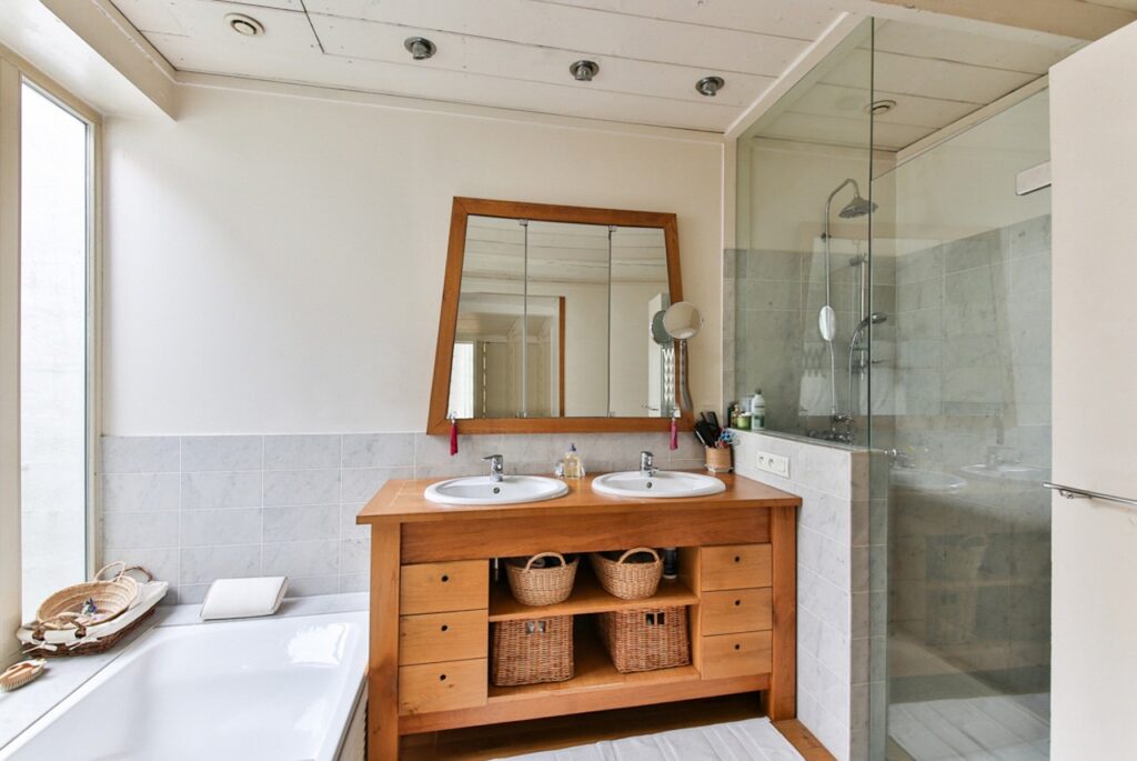 Modern accessible bathroom renovation with walk-in shower and warm wood vanity