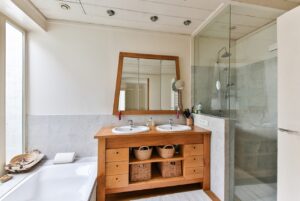 Modern accessible bathroom renovation with walk-in shower and warm wood vanity