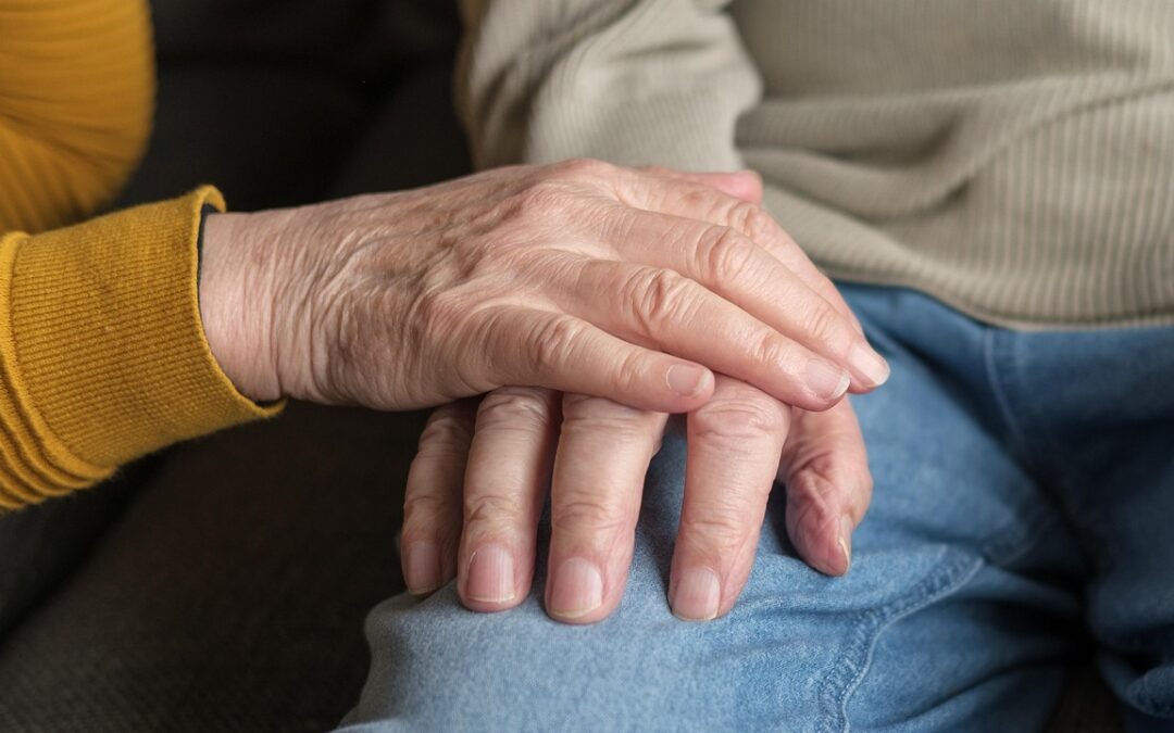 Senior couple holding hands at home, illustrating aging in place in British Columbia
