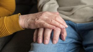 Senior couple holding hands at home, illustrating aging in place in British Columbia